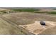 Expansive aerial view of a modern home on a sprawling lot, surrounded by farmland and an inviting driveway at 65960 E Evans Pl, Byers, CO 80103