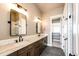 Bright bathroom with double vanity, undermount sinks, granite countertops and large mirrors at 65960 E Evans Pl, Byers, CO 80103