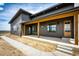 Beautiful home exterior showcases a covered porch with wood beams and a pathway leading to the inviting entrance at 65960 E Evans Pl, Byers, CO 80103
