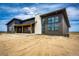 A modern exterior design with a stone chimney, large windows, and a covered porch perfect for relaxation at 65960 E Evans Pl, Byers, CO 80103