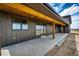 Inviting covered porch with sturdy wooden pillars and a walkway leading to the backyard at 65960 E Evans Pl, Byers, CO 80103