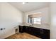 The laundry room boasts ample counter space and cabinets with natural light from the window at 65960 E Evans Pl, Byers, CO 80103