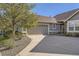 Charming home featuring a two-car garage, stone accents, and a mature tree at 7774 S Biloxi Way, Aurora, CO 80016