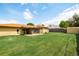 Large backyard with lush lawn, mature trees, sunroom and storage shed provides ample outdoor space at 85 S Flower St, Lakewood, CO 80226