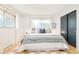 Bright bedroom featuring large windows, hardwood floors, and a cozy queen size bed with comfortable bedding at 85 S Flower St, Lakewood, CO 80226