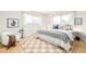 Bright bedroom features hardwood floors, large windows and a queen size bed with a cozy blanket at 85 S Flower St, Lakewood, CO 80226