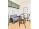 Bright breakfast nook with a gray couch, hardwood floors, a gold table, and lovely green overhead cabinets at 85 S Flower St, Lakewood, CO 80226