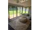 Bright sunroom with floor-to-ceiling windows, stylish seating, and access to the outdoor patio space at 85 S Flower St, Lakewood, CO 80226