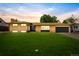 Charming, single-story brick home with a lush lawn and a covered front porch at sunset at 85 S Flower St, Lakewood, CO 80226