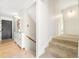Inviting hallway with hardwood floors, stairway access, shoe cabinet and light neutral paint throughout at 85 S Flower St, Lakewood, CO 80226