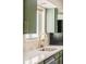 Close-up of kitchen sink area with golden faucet, white backsplash, and overhead olive cabinets at 85 S Flower St, Lakewood, CO 80226
