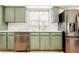 Modern kitchen with stainless steel appliances, olive cabinets and sleek white countertops at 85 S Flower St, Lakewood, CO 80226