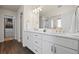 Elegant bathroom featuring a double vanity with quartz countertop, wood-look flooring and ample storage space at 7166 S Vandriver Way, Aurora, CO 80016