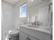 Clean white bathroom with a combined shower and tub, a single sink vanity, and natural light from the window at 7166 S Vandriver Way, Aurora, CO 80016