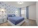 Stylish bedroom with blue floral wallpaper, a modern bed frame, and matching curtains and bedside tables at 7166 S Vandriver Way, Aurora, CO 80016