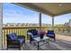 Covered deck features outdoor seating, wood railing, and scenic views of the community at 7166 S Vandriver Way, Aurora, CO 80016