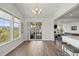 Dining area with wood floors, a modern chandelier, and sliding glass doors opening to the covered deck at 7166 S Vandriver Way, Aurora, CO 80016