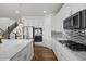 Well-equipped kitchen with white cabinets, stainless steel appliances, and a stylish backsplash at 7166 S Vandriver Way, Aurora, CO 80016