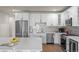 Modern kitchen with white cabinets, stainless steel appliances, an island, and a tiled backsplash at 7166 S Vandriver Way, Aurora, CO 80016