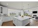 Bright kitchen with white cabinets, stainless appliances, island with quartz counters, and views of the backyard at 7166 S Vandriver Way, Aurora, CO 80016