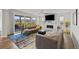 Inviting living room with a fireplace, a ceiling fan, neutral walls, large windows and sliding glass door to a deck at 7166 S Vandriver Way, Aurora, CO 80016