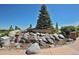 Entrance to the park featuring a natural stone water feature, landscaping, and signage under a clear sky at 1162 Rockhurst Dr # 404, Highlands Ranch, CO 80129