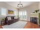 Cozy living room with comfortable seating, a fireplace, and bright natural light from the shuttered windows at 1162 Rockhurst Dr # 404, Highlands Ranch, CO 80129