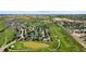 Aerial view of a community with a golf course, green spaces, and residential houses in a serene landscape at 311 Josef Cir, Fort Lupton, CO 80621