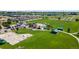Aerial view showcasing a community park with playground, picnic area, sports field, and parking at 311 Josef Cir, Fort Lupton, CO 80621
