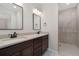 Bathroom with double vanity, decorative mirrors, and standing shower at 311 Josef Cir, Fort Lupton, CO 80621
