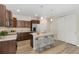 Modern kitchen with an island and seating, stainless steel appliances, and hardwood floors at 311 Josef Cir, Fort Lupton, CO 80621