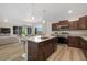 Open kitchen with stainless steel appliances, center island, and seamless view to living area at 311 Josef Cir, Fort Lupton, CO 80621