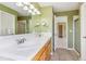 Bright bathroom with double sinks, large mirror, and a doorway to adjacent rooms at 2330 S Salem Cir, Aurora, CO 80014