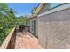Outdoor deck with wood railing, sliding glass door and a view to foliage and nearby building at 2330 S Salem Cir, Aurora, CO 80014