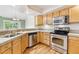 Eat-in kitchen featuring wooden cabinetry and stainless steel appliances, and hardwood floors at 2330 S Salem Cir, Aurora, CO 80014