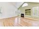 Bright living room with hardwood floors, a vaulted ceiling, and a fireplace with built-in shelving at 2330 S Salem Cir, Aurora, CO 80014