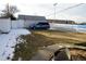 View of the backyard featuring a storage shed, grass, a white fence and the school behind the property at 3901 S Washington St, Englewood, CO 80113