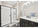 Modern bathroom with a walk-in shower, dark vanity, and sleek fixtures at 6980 S Yantley Ct, Aurora, CO 80016