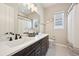 This bathroom features a double vanity with dark cabinets, sleek fixtures, and a shower, providing a functional and stylish space at 6980 S Yantley Ct, Aurora, CO 80016