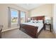This bedroom features a dark wood bed frame, soft carpeting, large window, and a calming color scheme, creating a cozy retreat at 6980 S Yantley Ct, Aurora, CO 80016