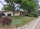 Ranch-style home with a two car garage, colorful landscaping, and stone accents at 7409 Pierce St, Arvada, CO 80003
