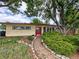 Charming ranch home with a welcoming red door and lush landscaping at 7409 Pierce St, Arvada, CO 80003
