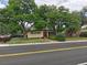 Street view of home with a red door, large trees, and a well-manicured lawn, enhancing its curb appeal at 7409 Pierce St, Arvada, CO 80003