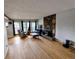 Cozy living room with hardwood floors, large windows, stone fireplace, and neutral paint at 7409 Pierce St, Arvada, CO 80003