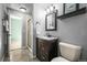 Gray bathroom with glass enclosed shower, single sink vanity, and adjacent toilet at 10831 Eagle Crest Ln, Parker, CO 80138