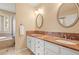 Bathroom with a double sink vanity featuring granite countertops and oval mirrors at 10831 Eagle Crest Ln, Parker, CO 80138