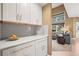 Convenient butler's pantry with white cabinets, gold hardware and grey backsplash at 10831 Eagle Crest Ln, Parker, CO 80138