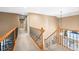 Carpeted hallway with wood and iron banister leading to the second floor at 10831 Eagle Crest Ln, Parker, CO 80138