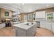 Kitchen with large island, white cabinets, stainless appliances, and an eat-in kitchen table next to the living room at 10831 Eagle Crest Ln, Parker, CO 80138