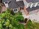 Aerial view of a home with a well-manicured front yard and brick accents, complemented by mature trees at 930 W Dry Creek Rd, Littleton, CO 80120